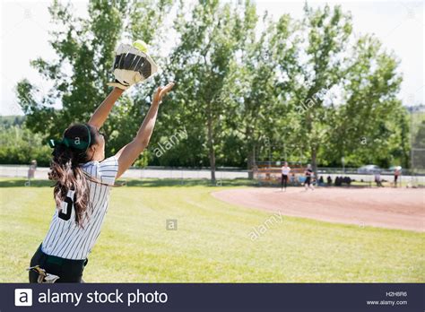 Middle School Girl Softball Player Catching Softball In Outfield Stock