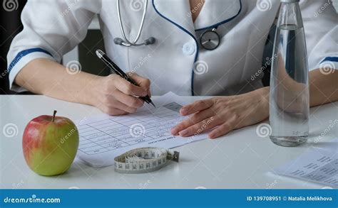 Nutritionist Doctor Writing Diet Plan On Table Healthy Lifestyle And