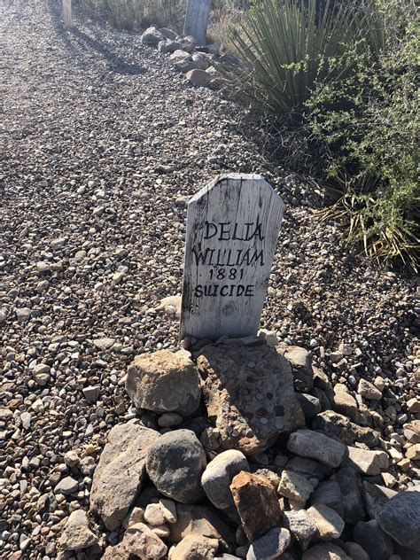 a grave marker in the middle of a rocky area