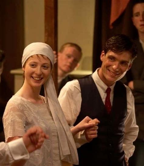 Two People Dressed In Old Fashioned Clothing Are Smiling And Dancing