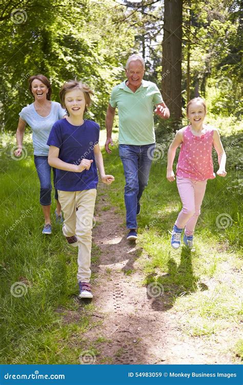 Grands Parents Avec Des Petits Enfants Courant Par La Campagne Image