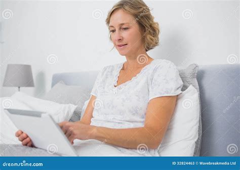 Blonde Smiling Woman Sitting In Bed Using Tablet Pc Stock Image Image