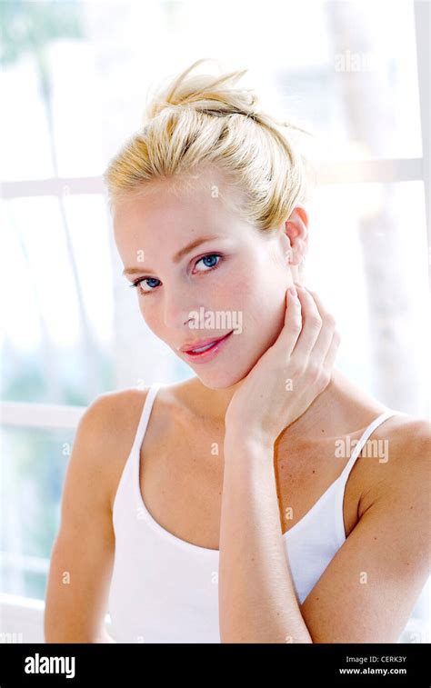 Female With Blonde Hair Tied Up Wearing White Vest Top Hand On Neck Stock Photo Alamy