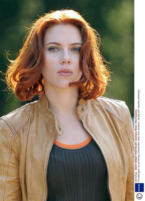 A Woman With Red Hair Wearing A Brown Jacket