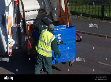 Council Dustman Collecting Household Recycling And Emptying Into Bin