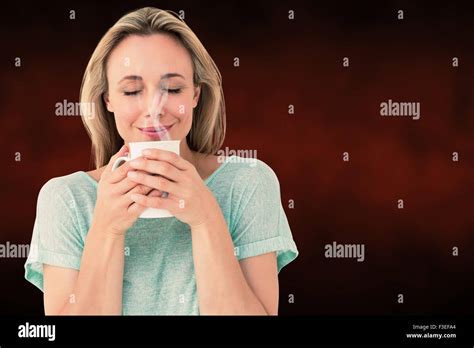 Composite Image Of Cheerful Blonde Holding Mug Of Hot Drinking Stock Photo Alamy