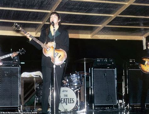 The Beatles Performing On Stage In Front Of Microphones And Guitar