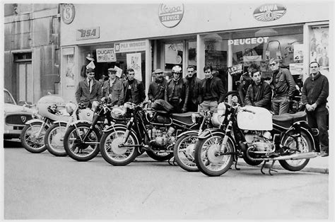 A Group Of Men Standing Next To Motorcycles In Front Of A Building With