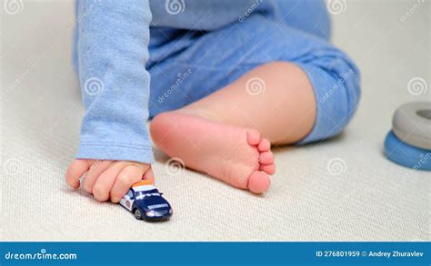 Toddler Baby Boy Is Playing With Toy Cars On The Floor In The Home Room