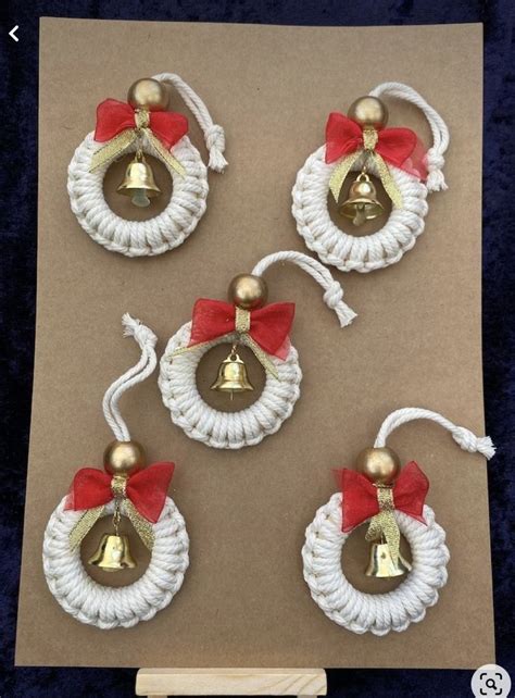 Three Bells With Red Bows On Them Are Hanging From Strings In Front Of