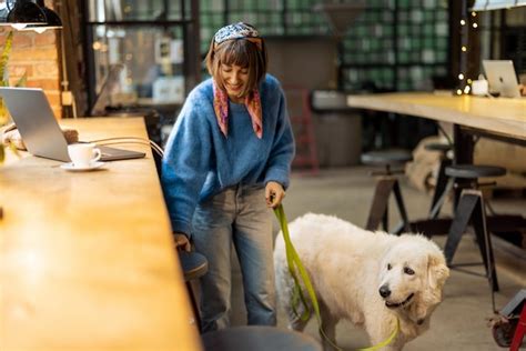 Una Mujer Trabaja En Una Laptop Mientras Se Sienta Con Su Perro En Una