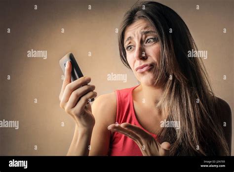 Confused Brunette Woman With Phone Stock Photo Alamy