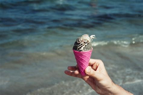 Pessoa Segurando Um Cone De Sorvete Na Praia Foto Premium