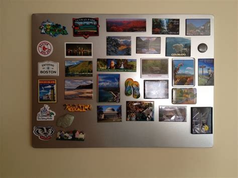 A Silver Refrigerator Covered In Magnets And Pictures