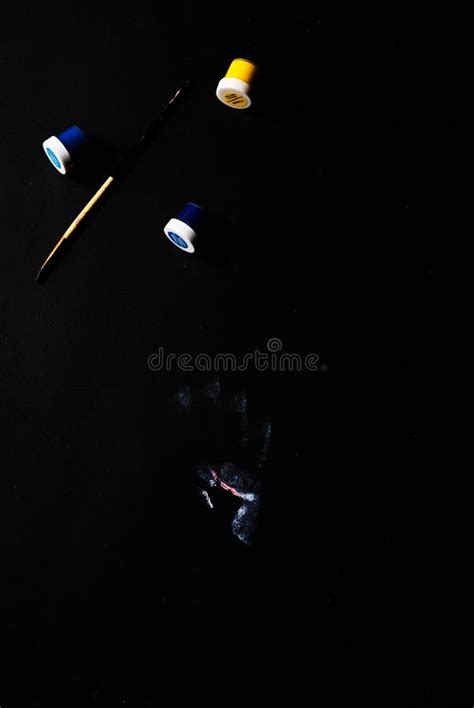 Handprint Brush And Jars Of Colored Paint On A Black Background Stock