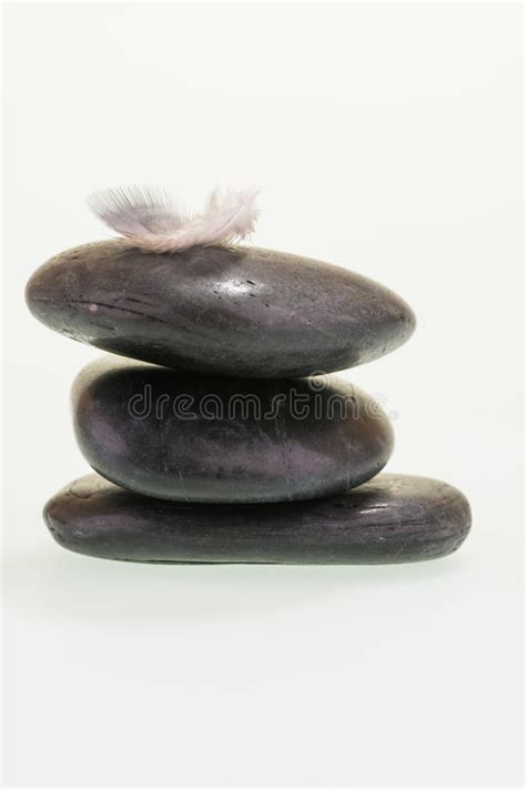 Pena Que Equilibra Na Pilha De Pedras Pretas Imagem De Stock Imagem