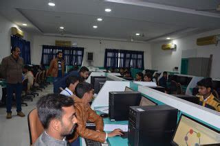 People Are Sitting At Desks In An Office Setting With Computers On The