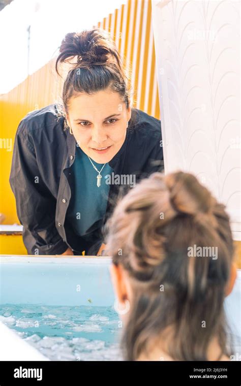 Girl Or Woman Bathing In The Cold Water Among Ice Cubes With Instructor