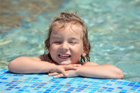 Jolie petite fille se baigner dans la piscine les yeux fermés image