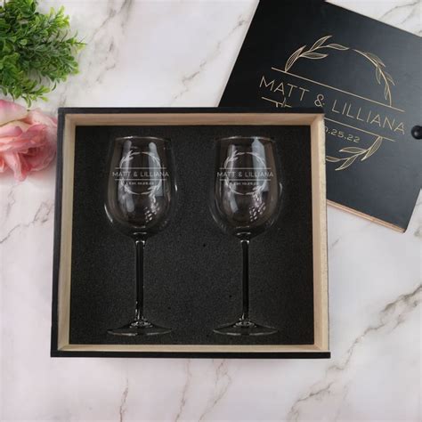 Two Wine Glasses Sitting In A Box On A Marble Counter Top Next To A