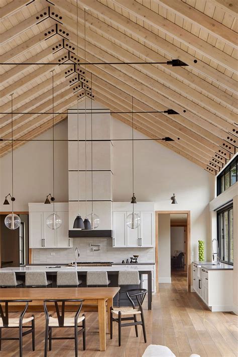 An Open Concept Kitchen And Dining Room With Wood Flooring White Walls