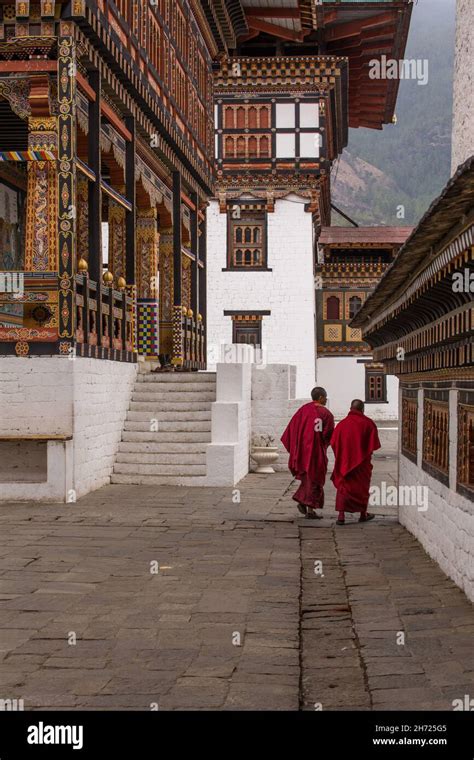 Two Buddhist Monks Walking Inside The Thimphu Dzong Complex In Thimphu