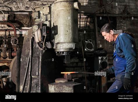 Blacksmith Processes A Hot Workpiece With A Pneumatic Hammer In A Workshop Stock Photo Alamy