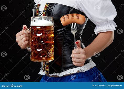 Young Woman With Dirndl Holds Oktoberfest Beer Stein On Black