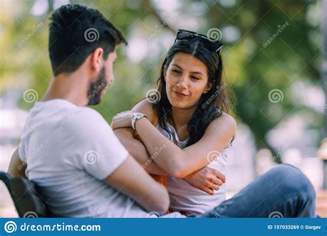 Multicultural Couple Having Conversation While Sitting On Bench Stock Image Image Of Nature