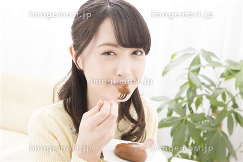 お菓子を食べる女性の写真素材 141548125 イメージマート