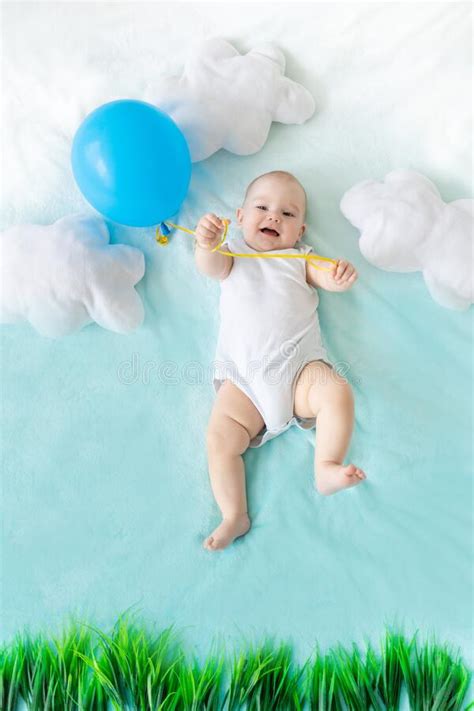 Un Beb Con Un Globo En La Mano Sobre Un Fondo Azul Del Cielo Con Nubes