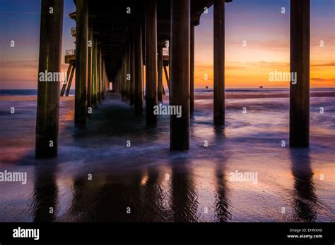 Under The Pier At Sunset In Huntington Beach California Stock Photo