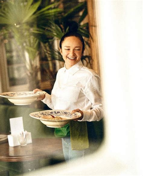 A Woman Holding Two Plates With Food On Them In Front Of A Window And