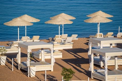 Plage De Sable De Luxe Avec Chaises De Plage Et Parasols En Paille