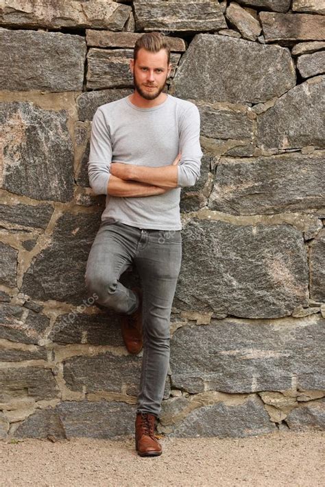 Handsome Man Standing Outside Leaning Against A Wall Stock Photo By