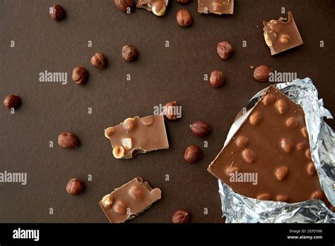 Milk Chocolate Bar With Hazelnuts In Foil Wrapper Stock Photo Alamy