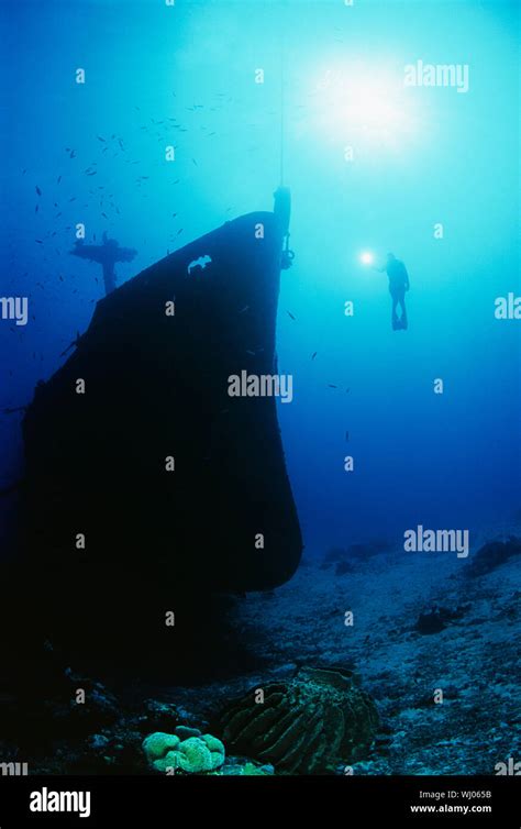 Underwater Shoot Of Female Scuba Diver Exploring Sunken Ship Stock