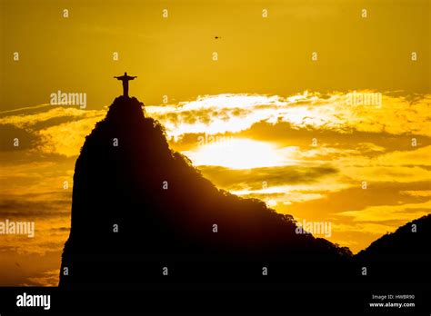 Christ the Redeemer at sunrise with a helicopter of a sightseeing tour flying nearby, Rio de ...