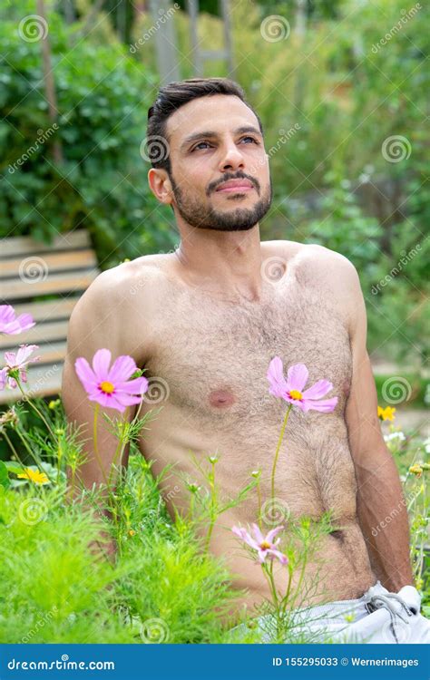 Handsome Shirtless Man With Beard Sitting Outside In Garden Stock Image