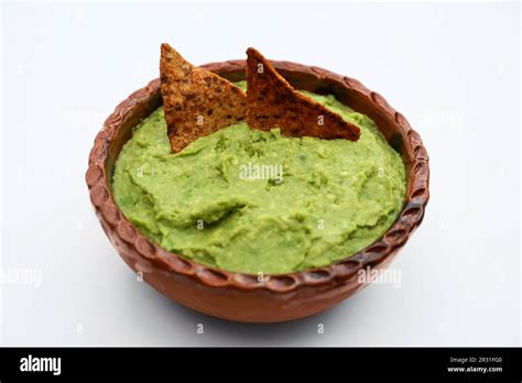 Delicious Guacamole Made Of Avocados With Nachos On White Background