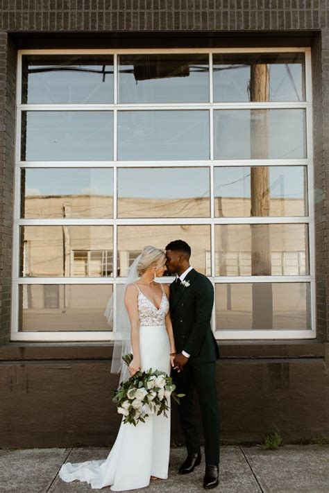 A Bride And Groom Standing In Front Of A Window