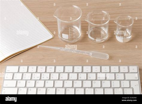 glass measuring beakers standing gradually on table and plastic pipette ...