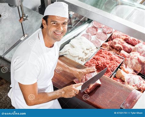 Smiling Butcher Cutting Meat At Counter Stock Photo Image 47231751