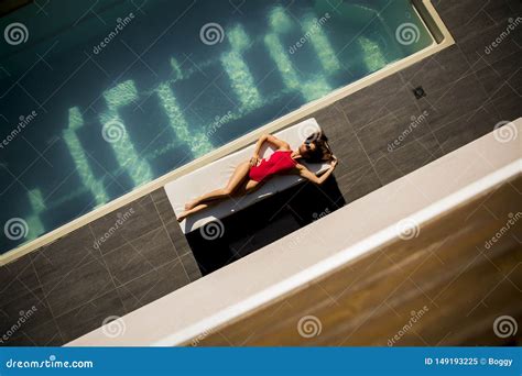 Beautiful Tanned Woman In Red Bikini Relaxing Near Luxury Swimming Pool