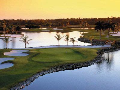 An Aerial View Of A Golf Course With Water And Palm Trees In The Foreground