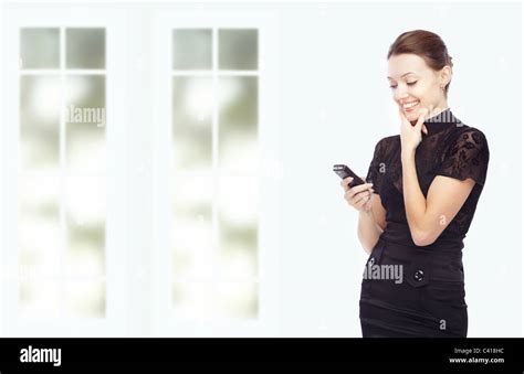 Smiling Lady Indoors Taking Pleasure From The Cell Phone Stock Photo