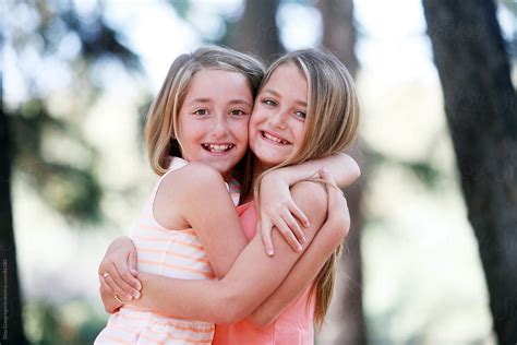 Joyful Twin Sisters Embracing Outdoors