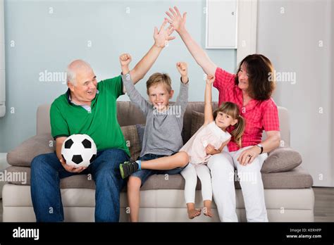 Familia de hinchas de fútbol viendo partido de fútbol en la televisión