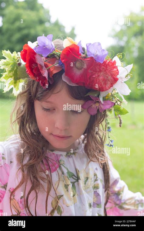 A Contemplative Girl With Long Hair Wears A Flower Crown With Red