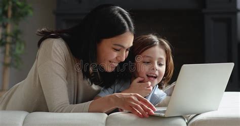 Caring Young Korean Asian Mom Teaching Son Using Computer Stock